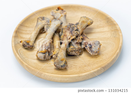 Chicken bone leftover wooden plate white background food waste cooked closeup horizontal unhealthy greasy messy Chicken bone leftover wooden plate white background food waste cooked closeup horizontal unhealthy greasy messy 131034215