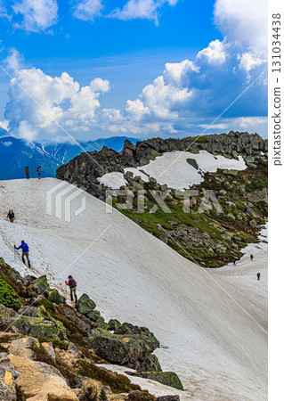 Climbers walking through the snowy fields and a magnificent view of the sky Climbers walking through the snowy fields and a magnificent view of the sky 131034438