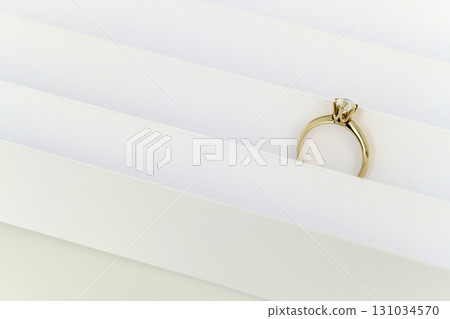 A gold ring with a diamond is on a white background 131034570