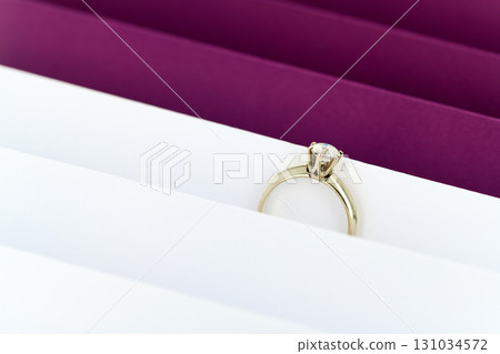 A gold ring is sitting on top of a stack of white paper 131034572
