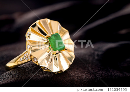 A gold and green emerald gemstone ring with diamonds A gold and green emerald gemstone ring with diamonds 131034593