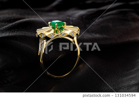 A gold and green emerald ring with diamonds on it A gold and green emerald ring with diamonds on it 131034594