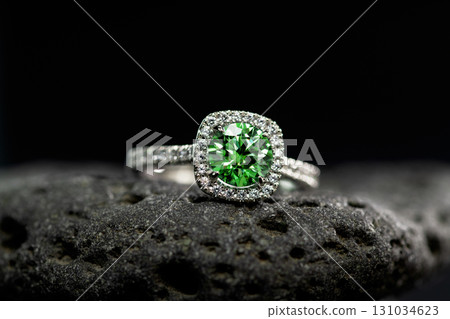 A green and white diamond ring sits on a rock A green and white diamond ring sits on a rock 131034623