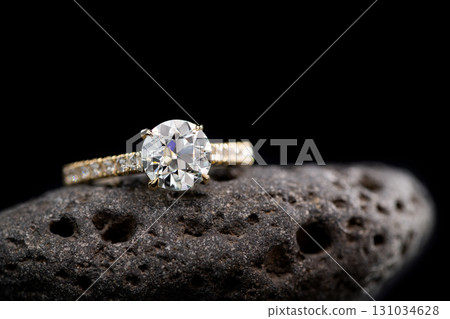 A diamond ring is on a rock 131034628