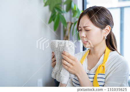 家庭主婦們對室內晾乾的潮濕衣服的氣味感到困擾 家庭主婦們對室內晾乾的潮濕衣服的氣味感到困擾 131035625