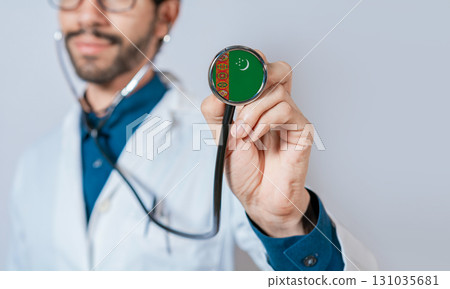 Doctor holding stethoscope with Turkmenistan flag. Turkmenistan health and care concept, Turkmenistan flag on stethoscope Doctor holding stethoscope with Turkmenistan flag. Turkmenistan health and care concept, Turkmenistan flag on stethoscope 131035681