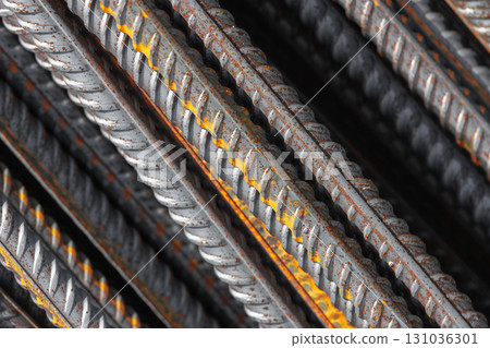 Detailed macro photo of steel reinforcement bars featuring orange rust Detailed macro photo of steel reinforcement bars featuring orange rust 131036301