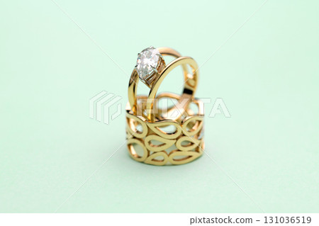 Gold Engagement Diamond Ring on Turquoise Background Gold Engagement Diamond Ring on Turquoise Background 131036519