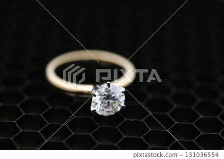 Solitaire Engagement Diamond Ring on Black Grid Background Solitaire Engagement Diamond Ring on Black Grid Background 131036554