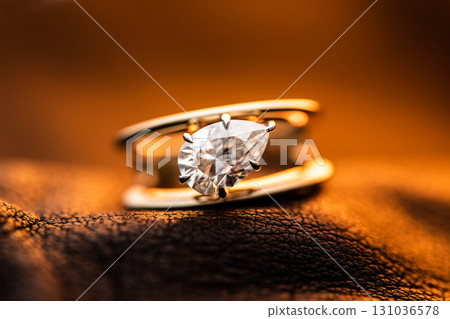 Engagement Diamond Ring on Golden Yellow Light background Engagement Diamond Ring on Golden Yellow Light background 131036578
