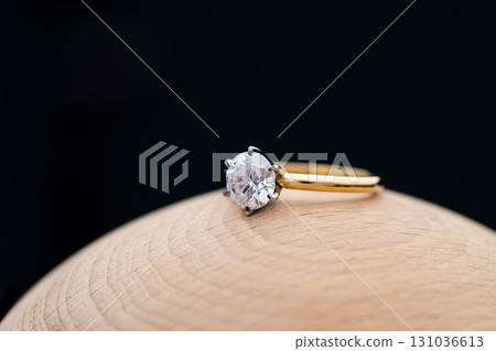 Gold Engagement Diamond Ring on Wooden Background Gold Engagement Diamond Ring on Wooden Background 131036613