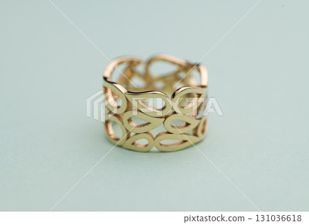 A gold ring with a design of leaves and a hole in the middle A gold ring with a design of leaves and a hole in the middle 131036618
