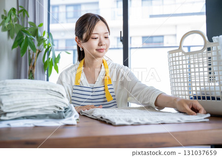 Housewife/housekeeper folding laundry 131037659