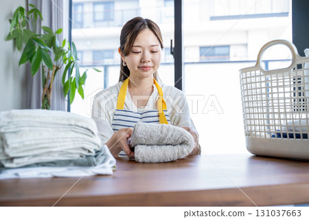 Housewife/housekeeper folding laundry 131037663