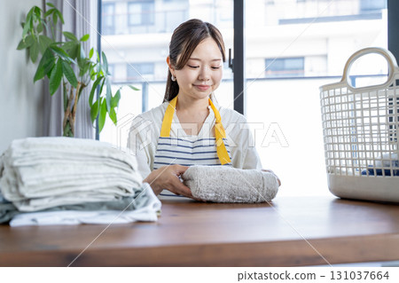 Housewife/housekeeper folding laundry 131037664