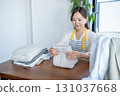 Housewife/housekeeper folding laundry 131037668