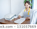 Housewife/housekeeper folding laundry 131037669