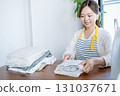 Housewife/housekeeper folding laundry 131037671