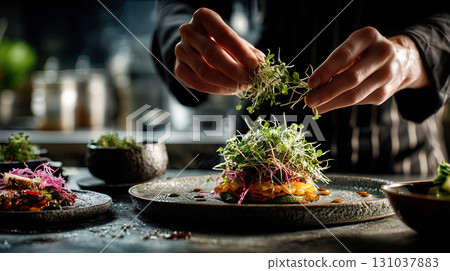 chef artfully places microgreens on dish chef artfully places microgreens on dish 131037883