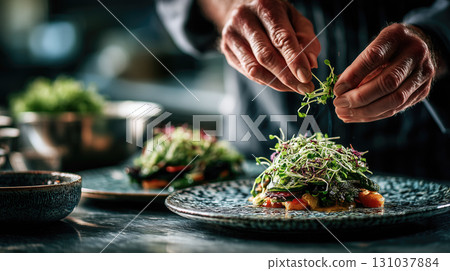 Chef garnishing dish with microgreens in fine dining setting 131037884