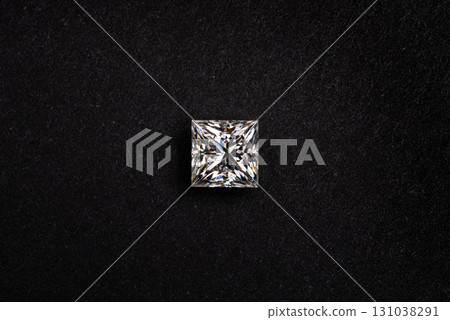 A diamond is sitting on a black surface 131038291