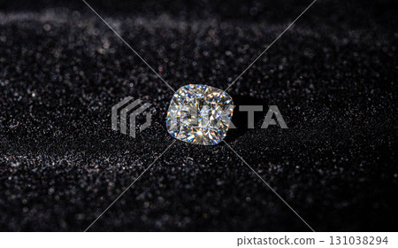 A diamond is sitting on a black surface 131038294