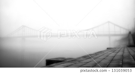 A solitary bridge emerges from the ethereal embrace of mist. 131039053