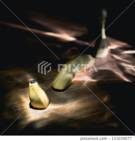 Yellow fresh banana on a black background in the rays of sun. 131039077