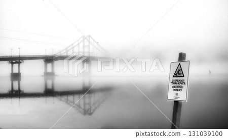 A solitary bridge emerges from the ethereal embrace of mist. 131039100