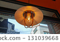 Warm glowing vintage edison bulb pendant light in cozy cafe interior 131039668
