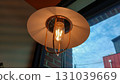Warm glowing vintage edison bulb pendant light in cozy cafe interior 131039669