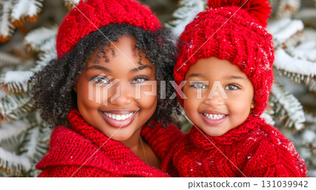 African American woman and girl in matching red sweaters smiling joyfully in winter wonderland 131039942