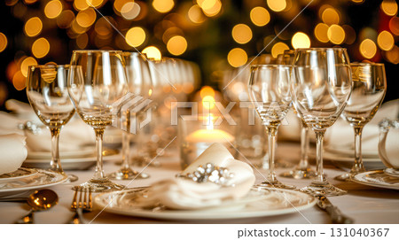 Elegant dining table set with sparkling glassware and soft candlelight ambiance for celebration 131040367