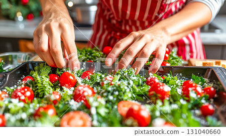 Hands of a chef arranging fresh vegetables and herbs on a baking tray for a delicious dish preparation 131040660