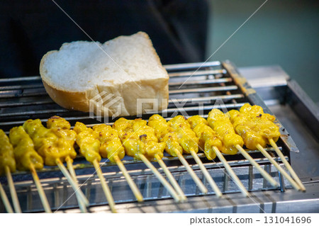 Skewer Raw Pork Satay and the bread on the grill grate Skewer Raw Pork Satay and the bread on the grill grate 131041696