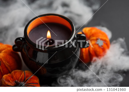 Halloween Candle in Cauldron with Pumpkins and Fog Halloween Candle in Cauldron with Pumpkins and Fog 131041980