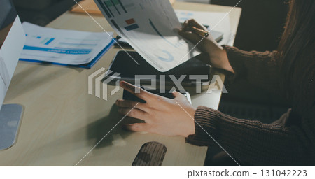 Close-up of businessman's hands making notes, mobiles, chart, desk, office 131042223