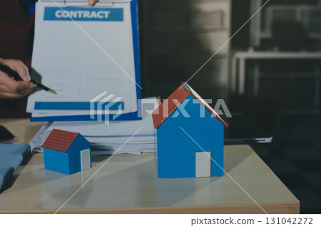 Customer signing a real estate contract in real estate agency. 131042272