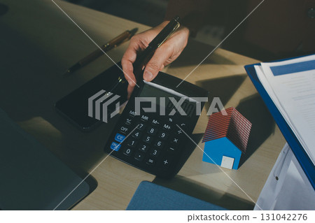 Customer signing a real estate contract in real estate agency. 131042276