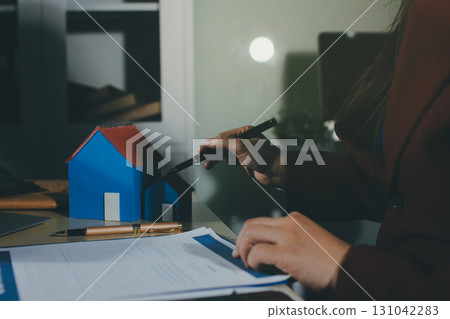 Customer signing a real estate contract in real estate agency. 131042283