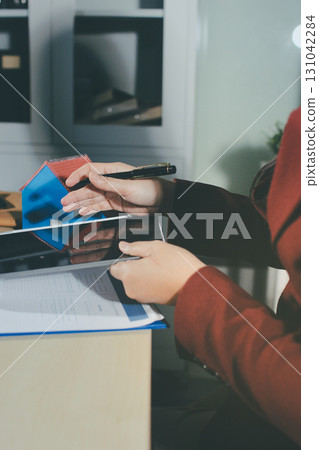 Customer signing a real estate contract in real estate agency. 131042284