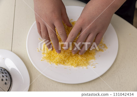 grated cheese in a wide white plate, grated cheese can be used to make pizza or cheese tortillas and other products. 131042434