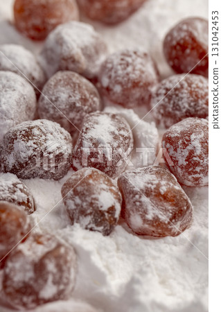dried kumquat and powdered sugar, sweet dried orange kumquat fruits in white powdered sugar dried kumquat and powdered sugar, sweet dried orange kumquat fruits in white powdered sugar 131042453