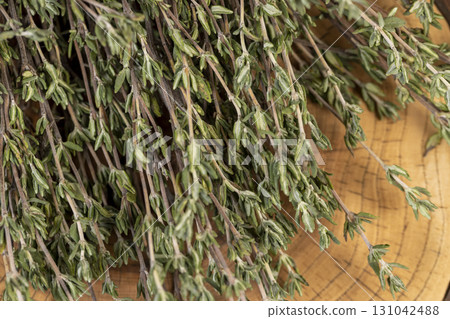 aromatic thyme spices bound together for use in cooking and folk medicine, thyme spices lying on a wooden table during drying aromatic thyme spices bound together for use in cooking and folk medicine, thyme spices lying on a wooden table during drying 131042488