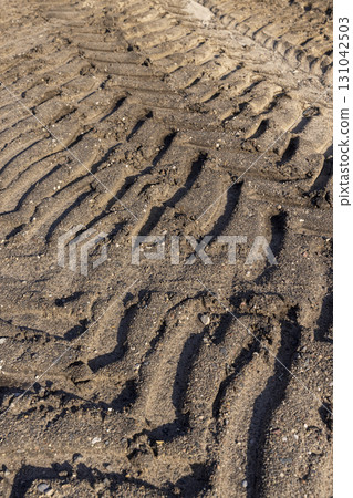 car tracks on the soil in the field, deep tracks from a very heavy vehicles in the field after harvesting 131042503