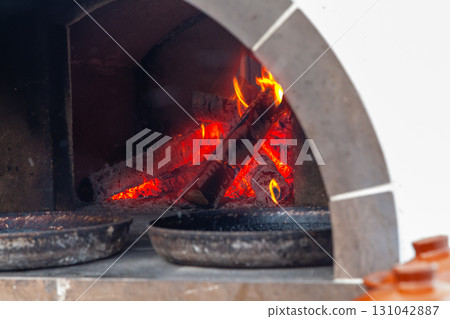 Cooking Flatbreads in a Russian Oven with Firewood 131042887