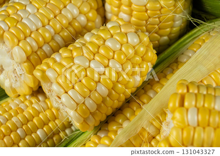 Detailed fresh raw corn cobs with natural texture close-up. Detailed fresh raw corn cobs with natural texture close-up. 131043327
