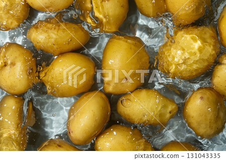 Whole Organic Raw Potatoes In Water Top View, Splash And Ripples. Whole Organic Raw Potatoes In Water Top View, Splash And Ripples. 131043335