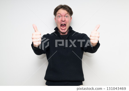 Portrait of happy Scandinavian mid adult man in black sweater smiling and giving thumbs up Portrait of happy Scandinavian mid adult man in black sweater smiling and giving thumbs up 131043469