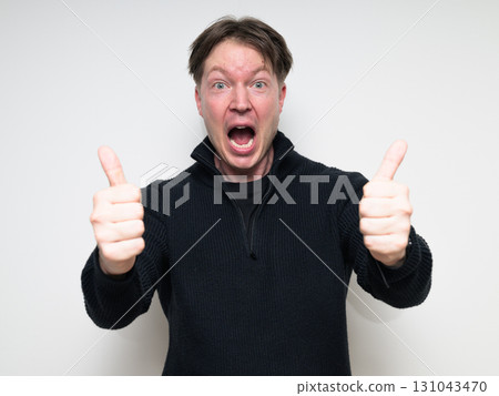 Portrait of happy Scandinavian mid adult man in black sweater smiling and giving thumbs up Portrait of happy Scandinavian mid adult man in black sweater smiling and giving thumbs up 131043470